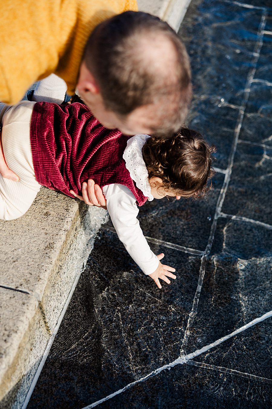 little girl playing in water with dad