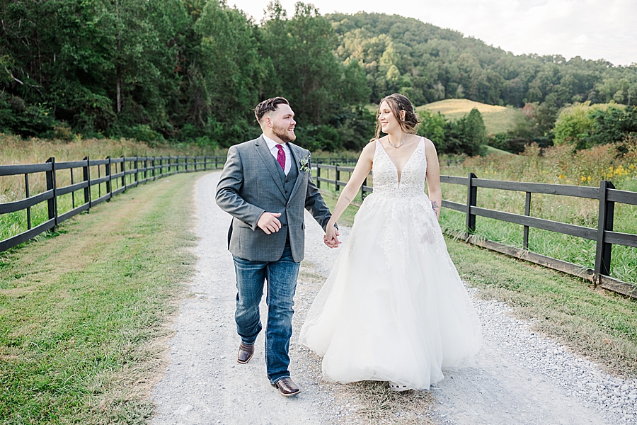 bride and groom running down gravel path