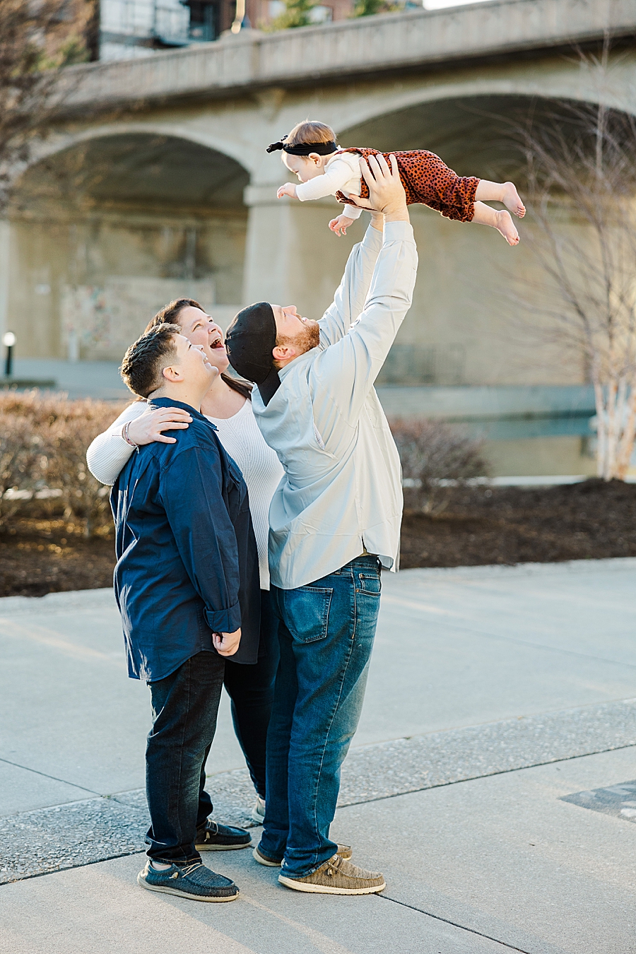 dad tossing daughter at 6 month session