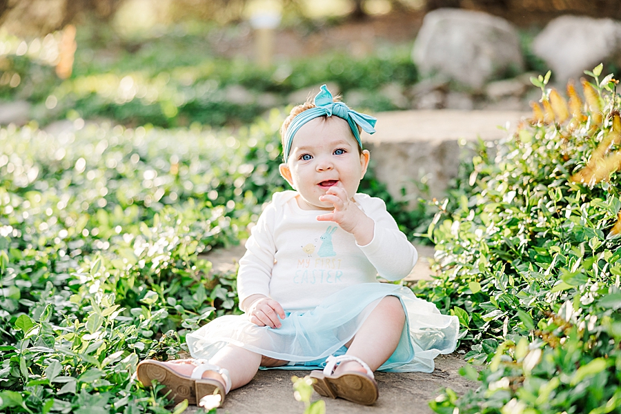 baby sitting in flowers at 9 month session