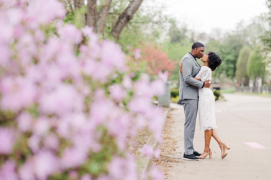 Kissing by the flowers at this Sequoyah Hills Proposal by Amanda May Photos.