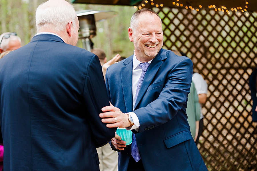 men shaking hands at backyard wedding
