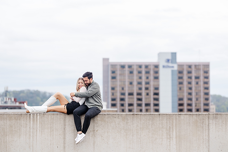 Sitting on wall laid back in his arms at this downtown Knoxville proposal by Amanda May Photos.