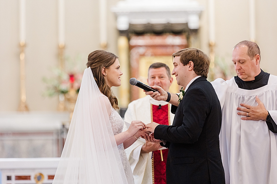 Bride placing ring on groom's hand at Julianna Wedding by Amanda May Photos