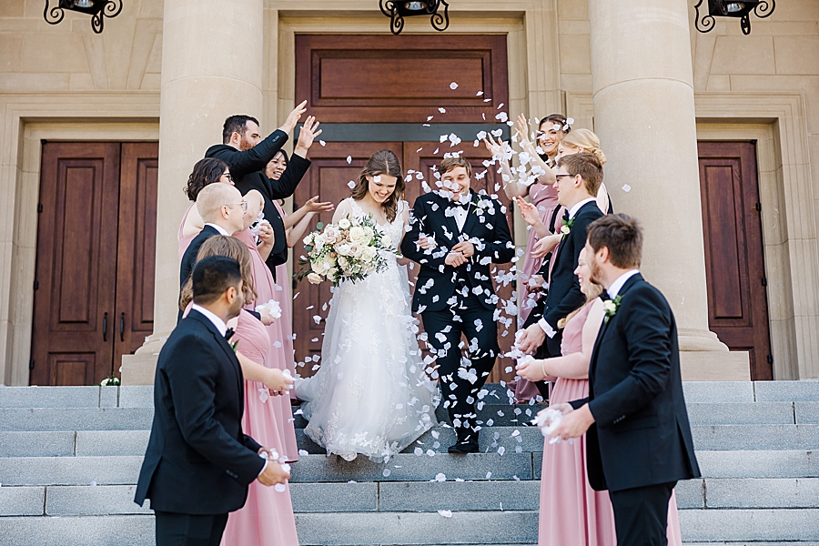 Wedding party throwing flower petals at wedding by Amanda May Photos