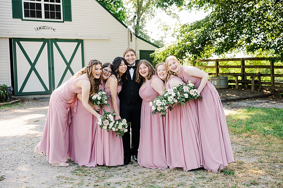 Groom and bridesmaids laughing at wedding by Amanda May Photos