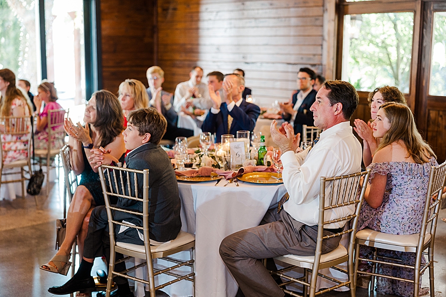 Guests clapping at wedding by Amanda May Photos