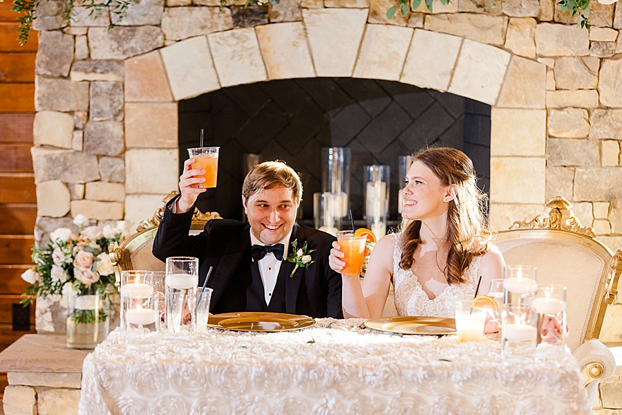 Bride and groom raise a glass at wedding by Amanda May Photos