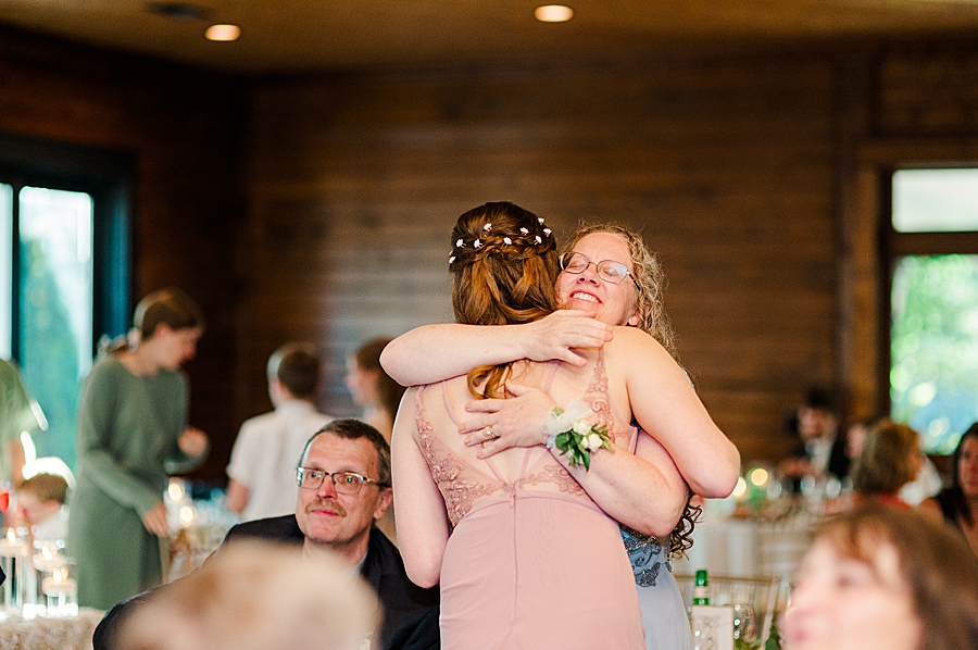 Bridesmaid and mom hugging at wedding by Amanda May Photos