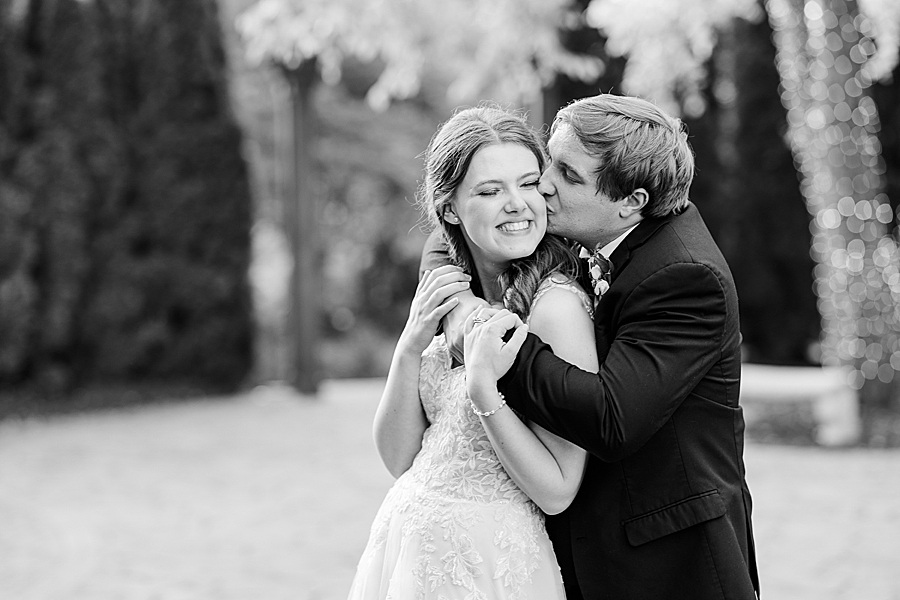 Kissing her cheek at wedding by Amanda May Photos