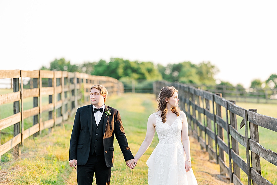 Holding hands and looking away at wedding by Amanda May Photos