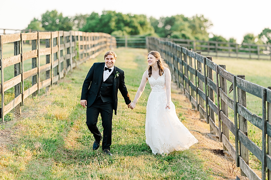 Holding hands and walking at wedding by Amanda May Photos