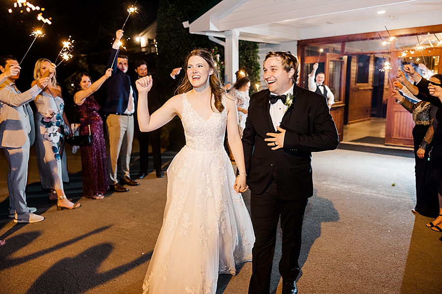 Bride and groom exiting at wedding by Amanda May Photos