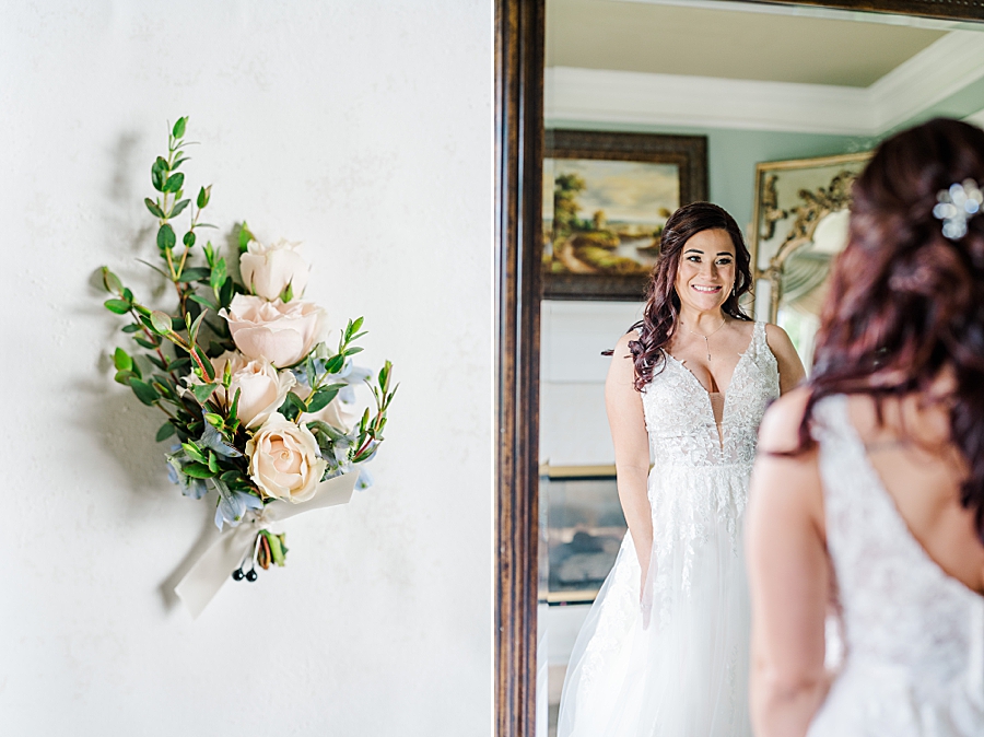 Bride looking in mirror at Carriage House Wedding by Amanda May Photos