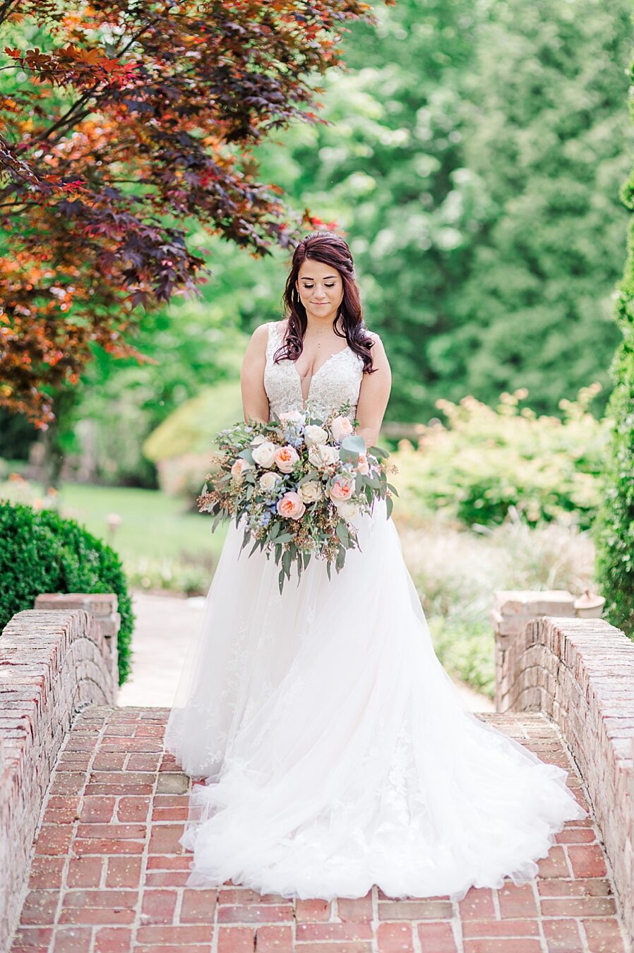 Bride smiling at flowers at Carriage House Wedding by Amanda May Photos