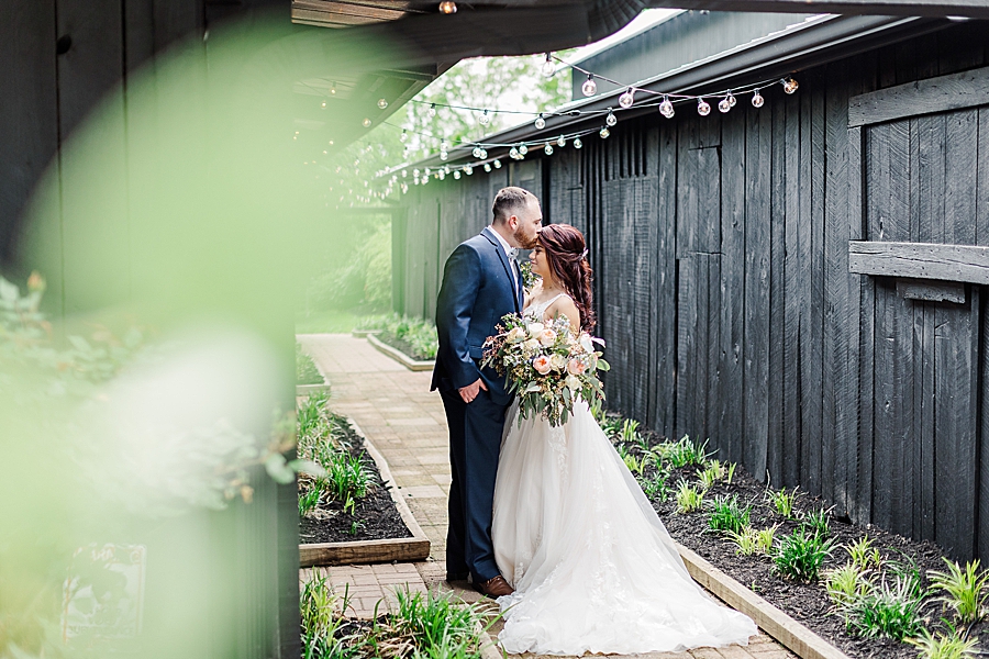 Kissing her forehead at Carriage House Wedding by Amanda May Photos