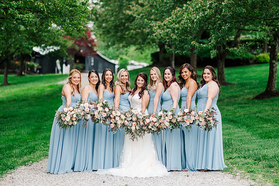 Bride and bridesmaids show off their flowers at Carriage House Wedding by Amanda May Photos