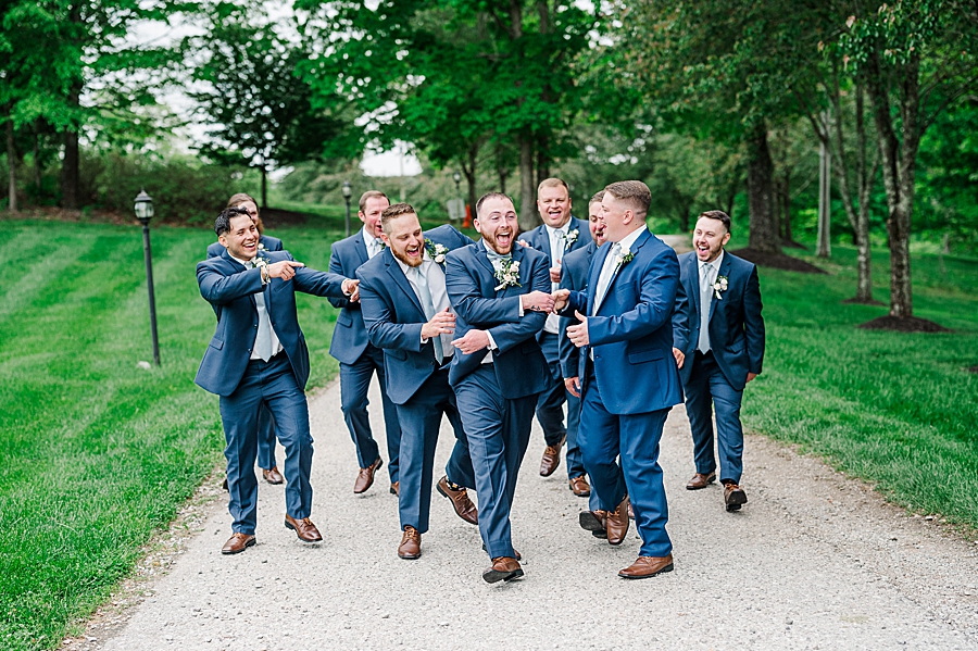 Groom laughing with groomsmen at Carriage House Wedding by Amanda May Photos