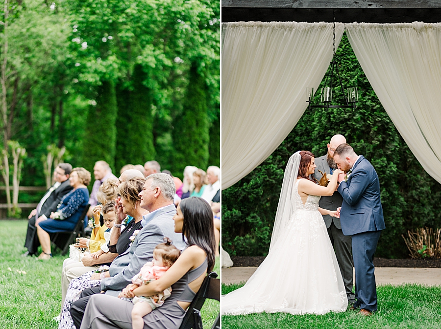 Groom kisses brides hand during ceremony at Wedding by Amanda May Photos