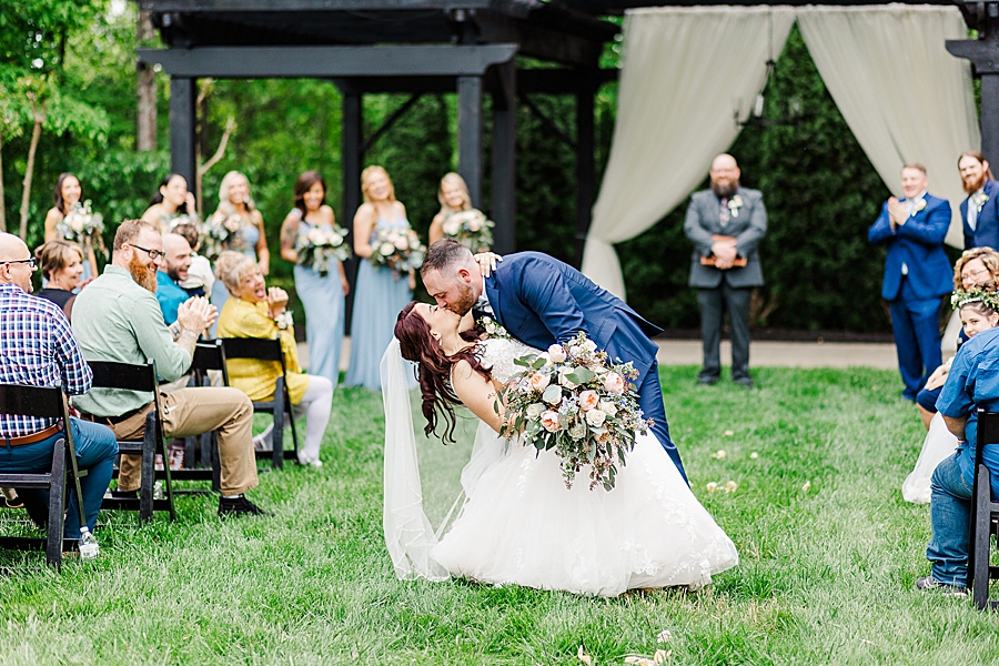 Groom kisses bride at Wedding by Amanda May Photos
