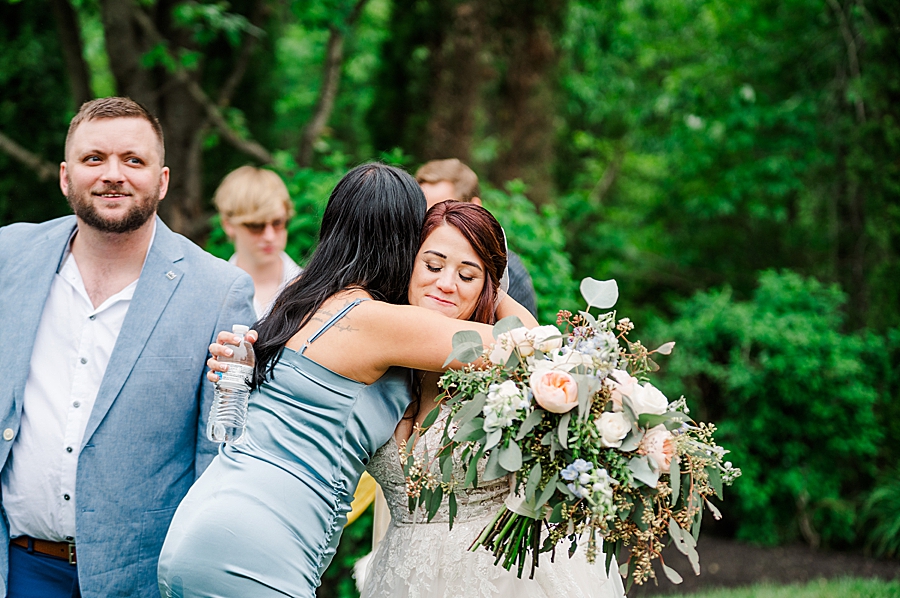 Bride and bridesmaid hug at Wedding by Amanda May Photos