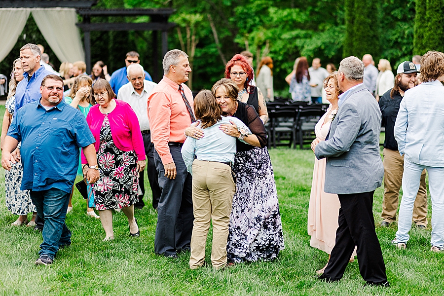 Guests hug at Wedding by Amanda May Photos