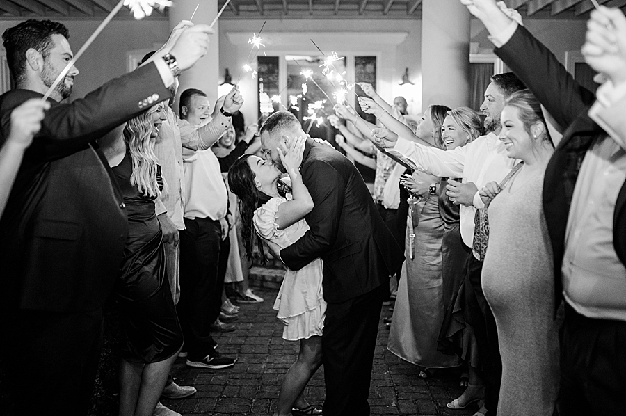 Bride and groom kiss during exit at Wedding by Amanda May Photos