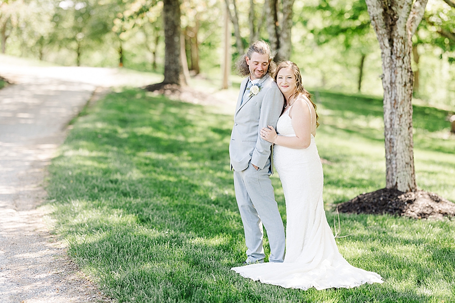 Hugging him from behind at Castleton Farms Wedding with a Rainbow by Amanda May Photos
