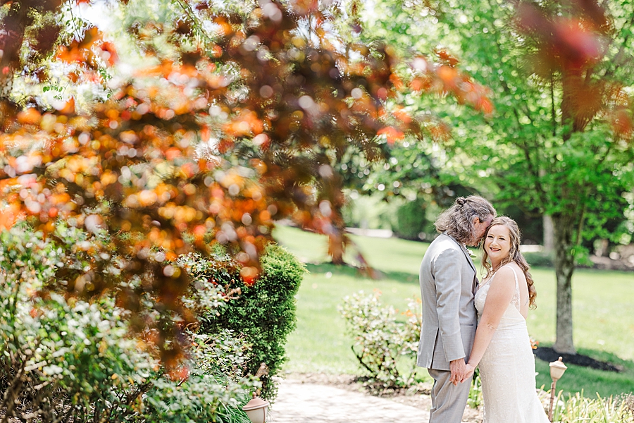 Whispering to her at Castleton Farms Wedding with a Rainbow by Amanda May Photos