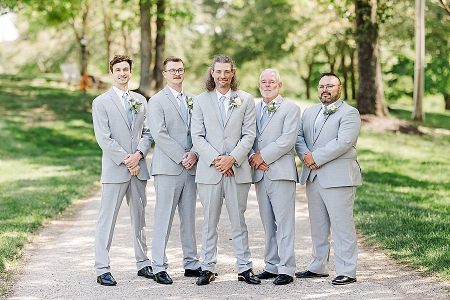 Groom and groomsmen standing at Castleton Farms Wedding with a Rainbow by Amanda May Photos
