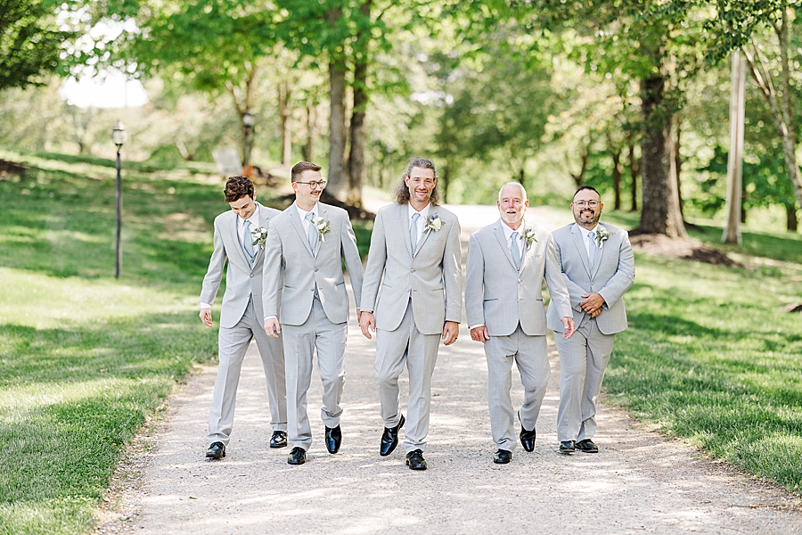 Groom and groomsmen walking at Castleton Farms Wedding with a Rainbow by Amanda May Photos