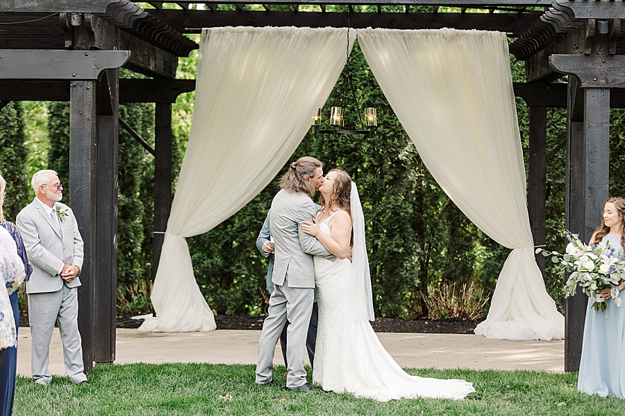 Bride and groom kiss during ceremony at Castleton Farms Wedding by Amanda May Photos