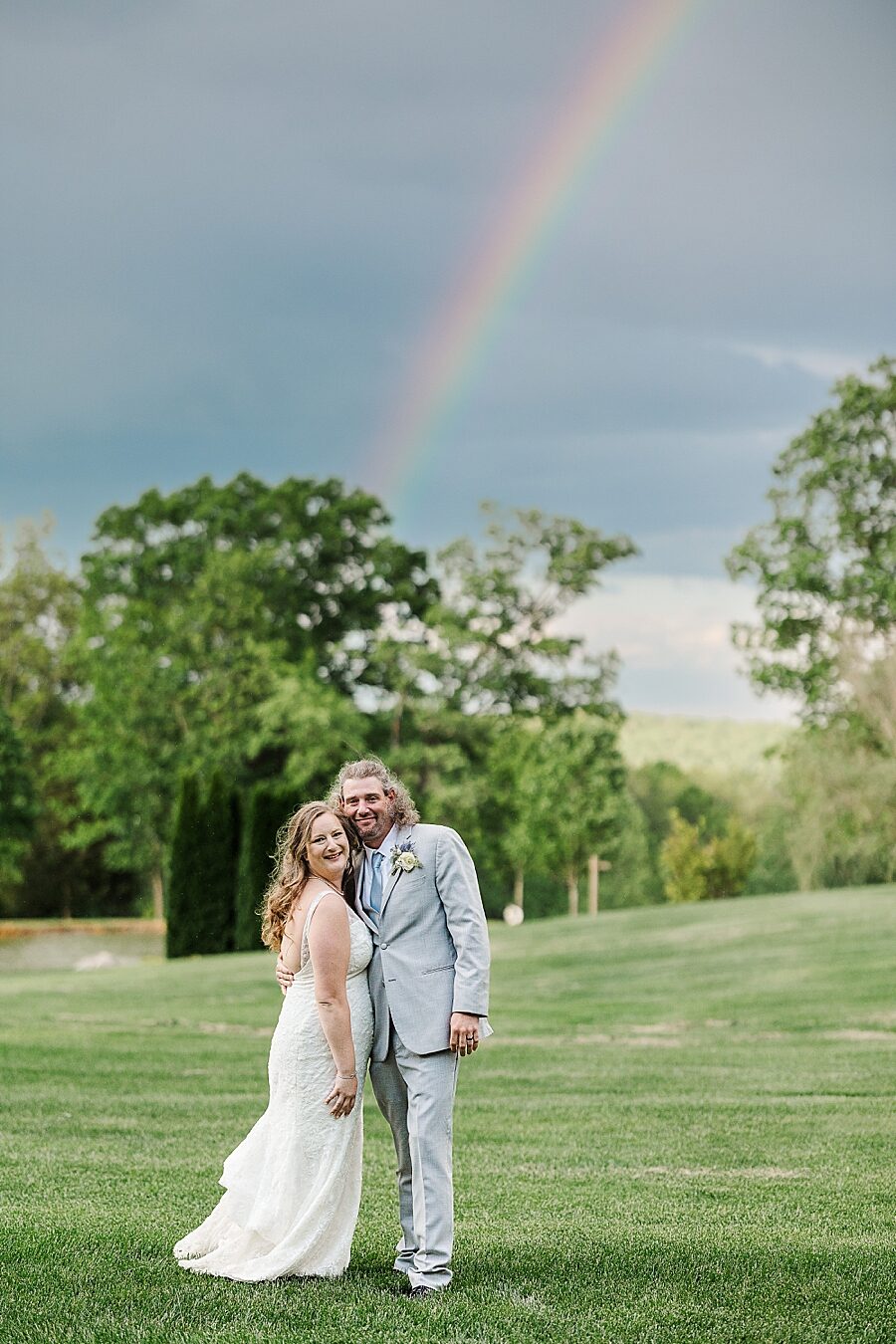 Smiling in front of the rainbow at Castleton Farms Wedding by Amanda May Photos