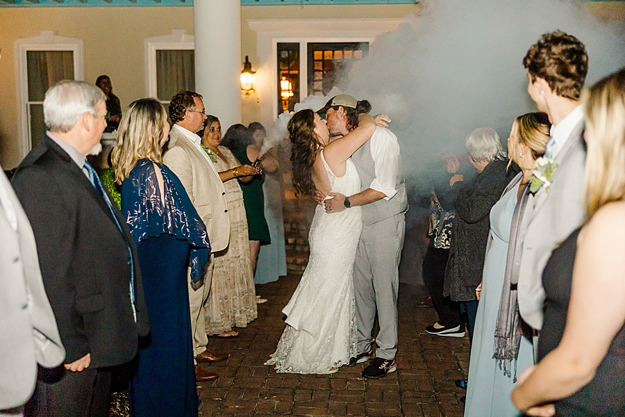 Kissing during exit at Castleton Farms Wedding by Amanda May Photos