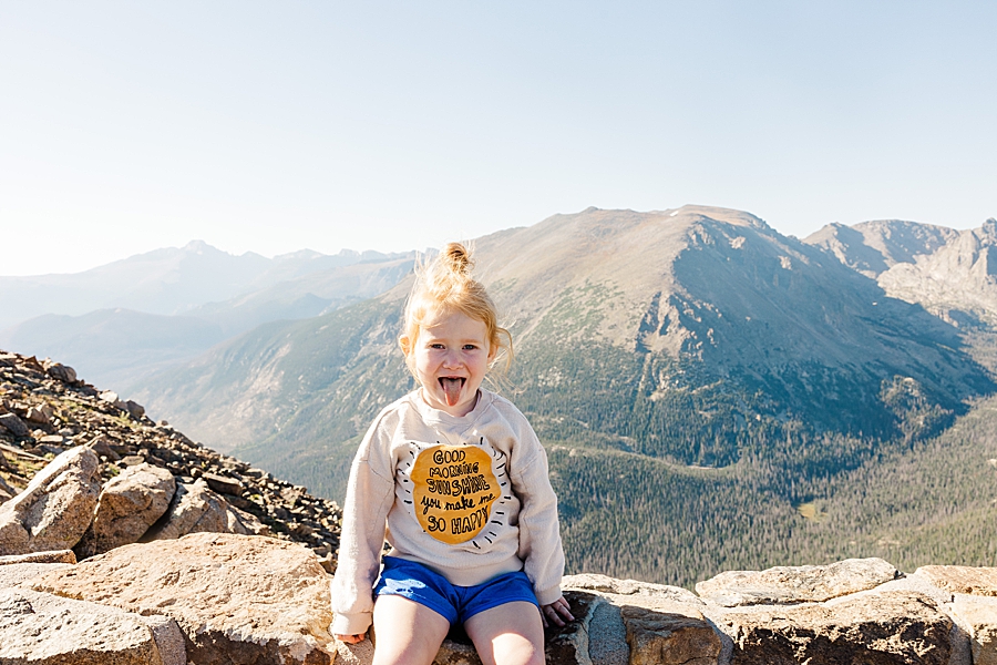 Little girl sitting on the rock wall in the Rocky Mountain National Park by Knoxville Wedding Photographer, Amanda May Photos.