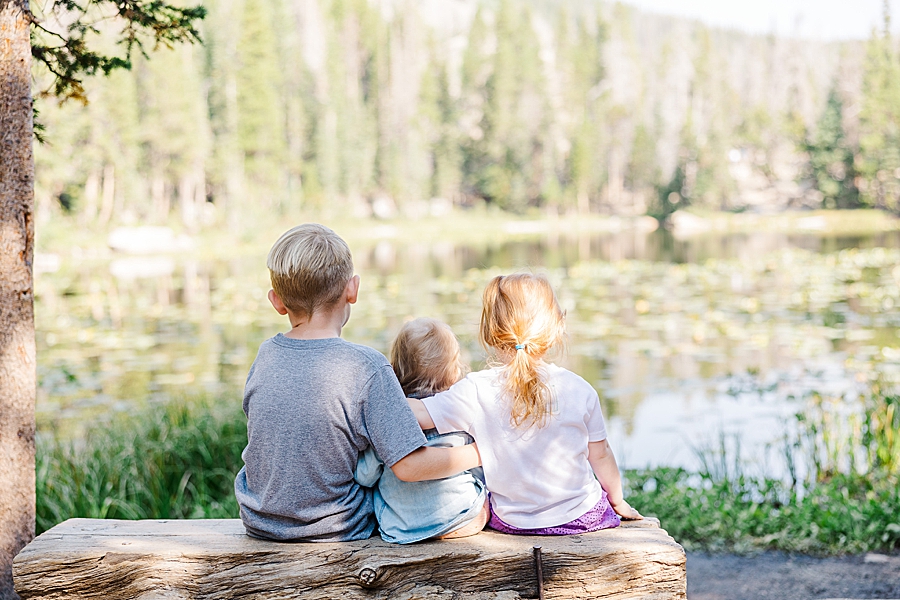 Three kids sitting on bench at the Nymph Lake in the Rocky Mountain National Park by Knoxville Wedding Photographer, Amanda May Photos.