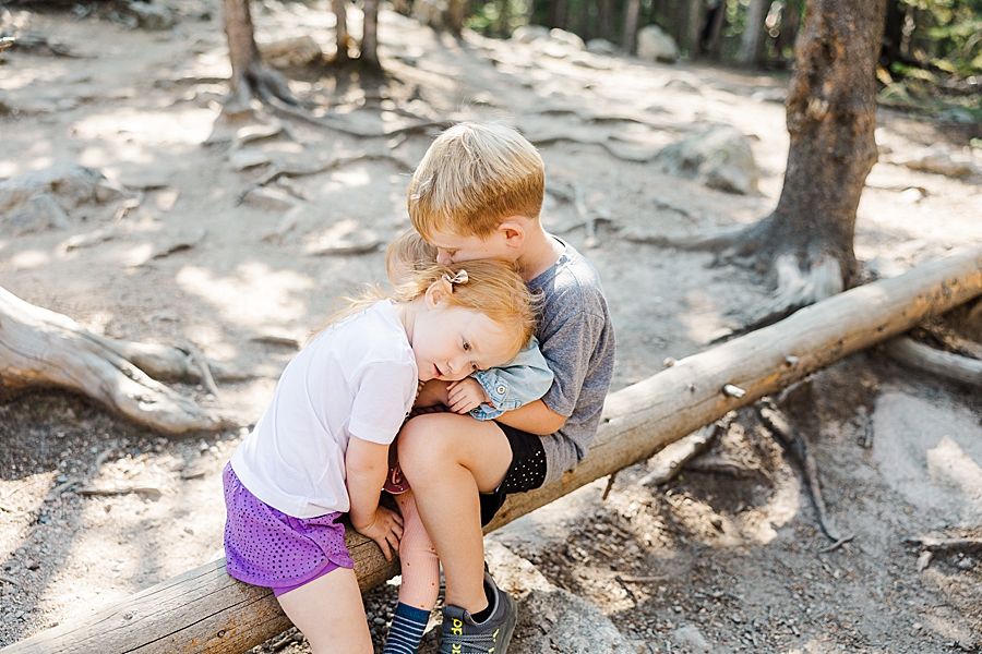 Big sister hugging little sister at the Nymph Lake in the Rocky Mountain National Park by Knoxville Wedding Photographer, Amanda May Photos.