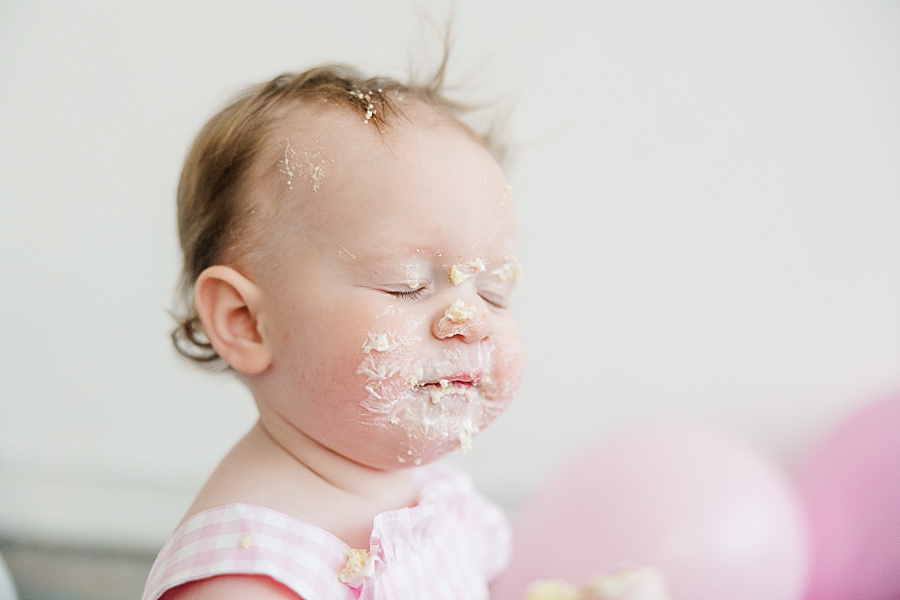 baby covered in icing during cake smash