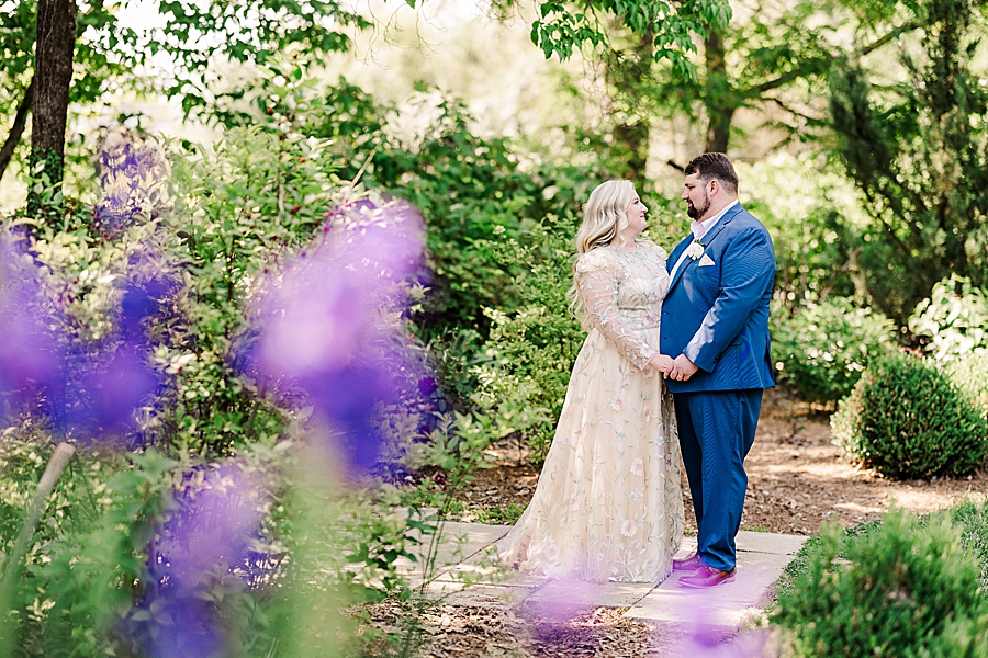 Standing by the flowers at Knoxville Botanical Gardens Wedding by Amanda May Photos