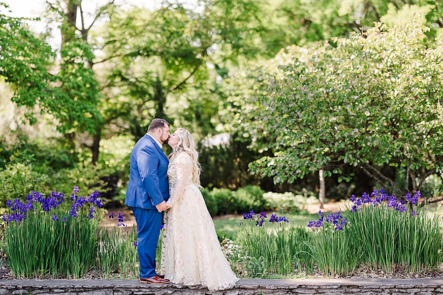 Kissing in front of the flowers at Knoxville Botanical Gardens Wedding by Amanda May Photos