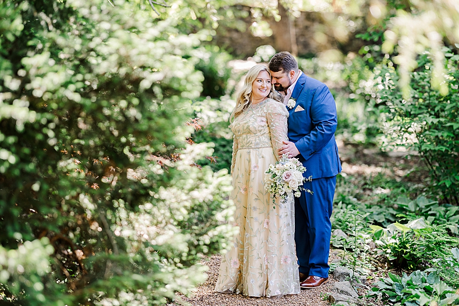 Hugging her from behind at Knoxville Botanical Gardens Wedding by Amanda May Photos