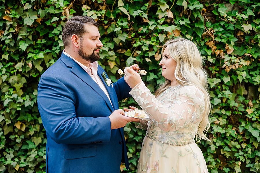 Bride and groom eat cake at Wedding by Amanda May Photos