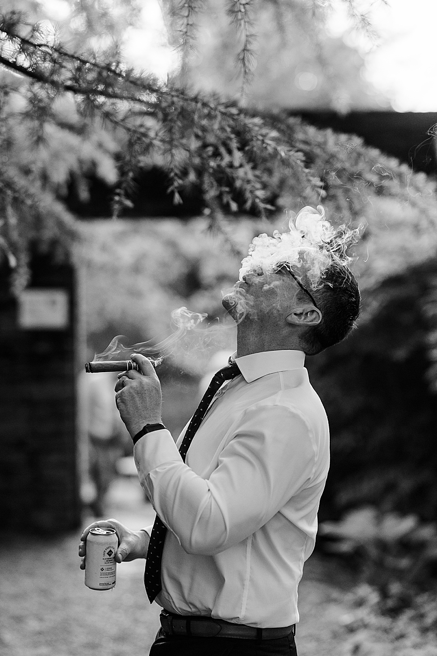 Guest blows a smoke cloud up at Wedding by Amanda May Photos