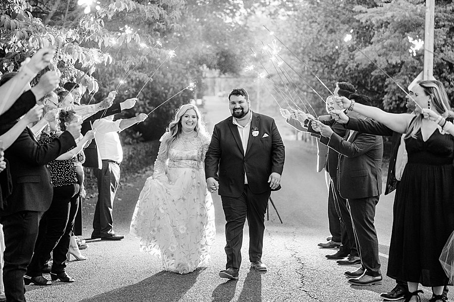 Bride and groom walking under sparklers at Wedding by Amanda May Photos