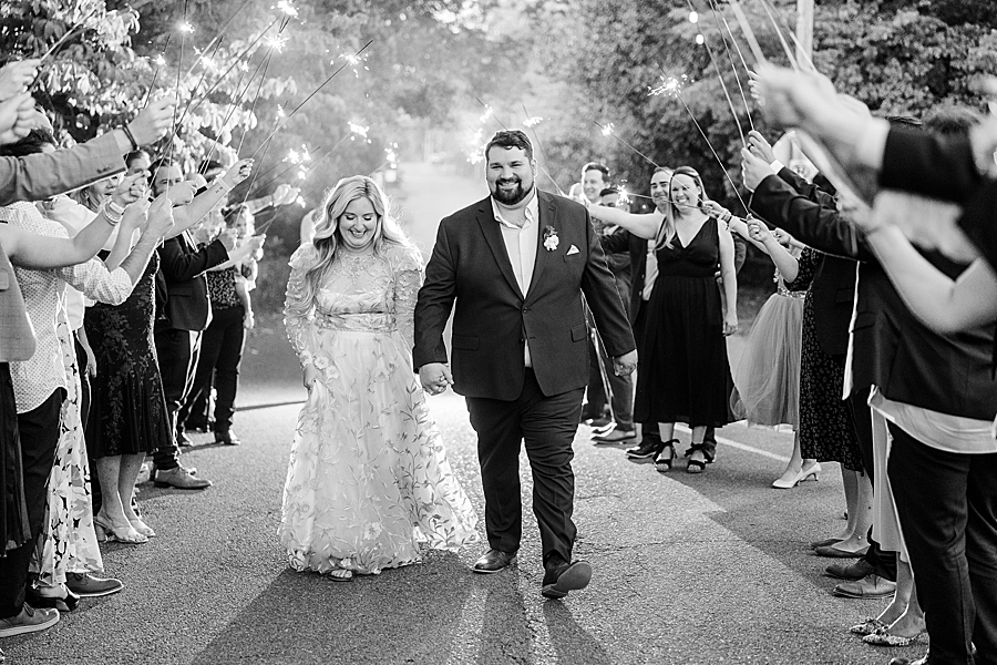 Bride and groom walking under sparklers at Wedding by Amanda May Photos