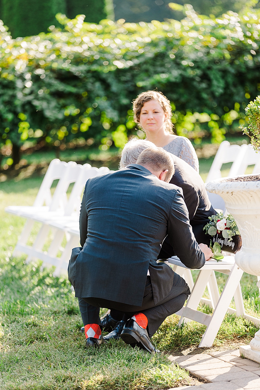 groom putting rose on chair
