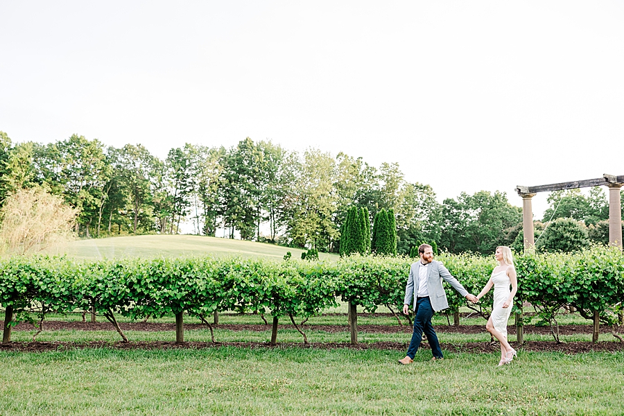 couple walking by grape vines