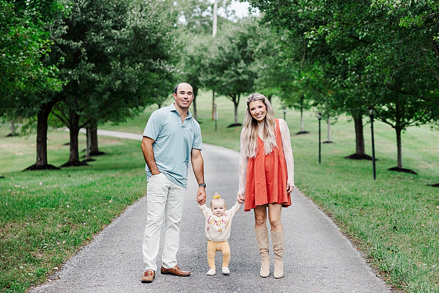 mom and dad holding daughter's hand