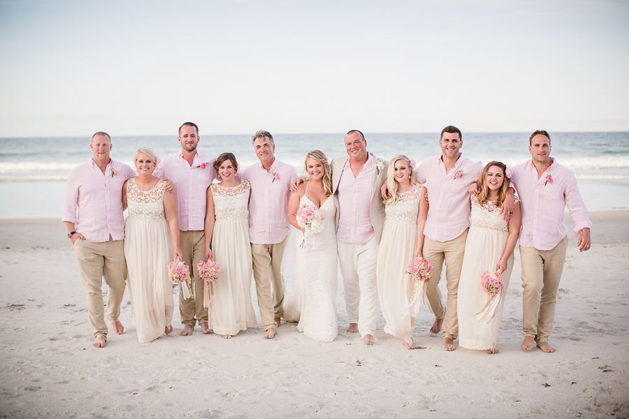 Bridal party with arms around each other on beach at this Daytona Beach Wedding by Destination Wedding Photographer, Amanda May Photos.