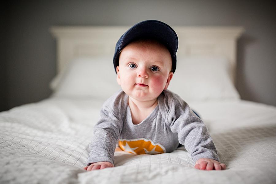 On his stomach with his hat on at this 6 months studio session by Knoxville Wedding Photographer, Amanda May Photos.